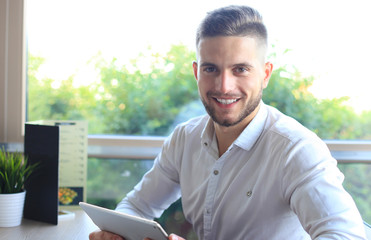 Modern businessman using tablet in the office cafe during lunch time