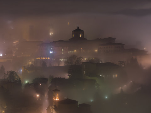 Bergamo - Old city (Cittˆ Alta). One of the beautiful city in Italy. Lombardia. The fog rises from the plains and wrap all the old city by creating lighting effects.