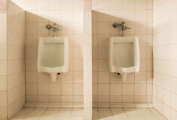 Closeup tiles wall in the toilet of man with toilet view by urinals