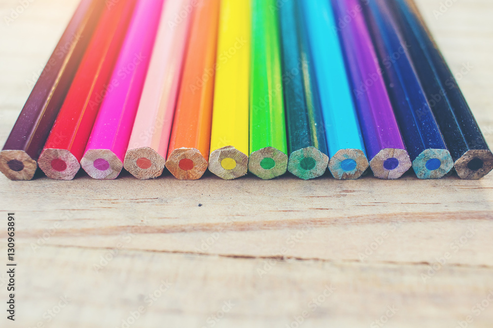 Wall mural close up of color pencils with different color over wood backgro