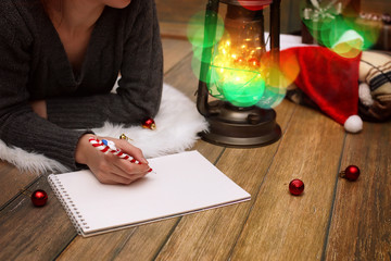 Obraz premium girl writes pen on a piece of paper Christmas wishes
