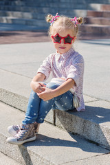Adorable little girl sitting on stairs