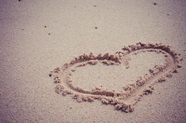 Heart drawing on sand beach