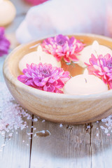 Candles and flowers on wooden background