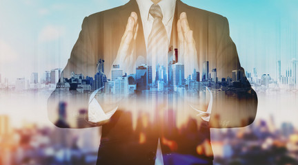 Double exposure businessman holding blue city hologram, real estate business technology