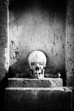 Totenkopf aus Stein am alten Südfriedhof in München - Monochrome