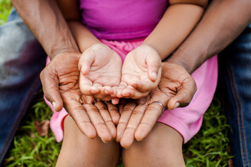 Hands of family together in green park - family unity and peace