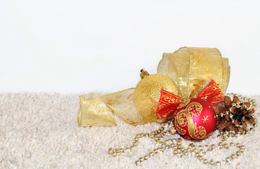 Gold and red Christmas balls, pine cone, ribbon decorations on l