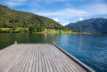 Wooden pier at norwegian fjord on a sunny summer day