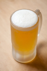 Mug of light beer on wood