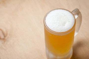 Mug of light beer on wood