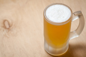 Mug of light beer on wood