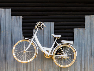 Fototapeta na wymiar White bicycle on wood wall