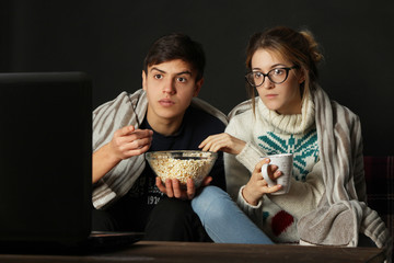 Young couple watching a movie in the evening on the sofa.