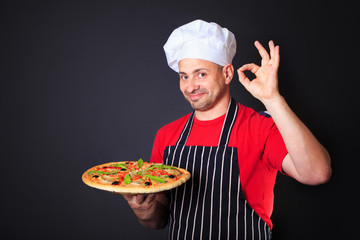 Portrait of happy attractive cook with a pizza in hands