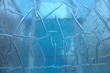 Frozen water in a colored plastic cube. Texture