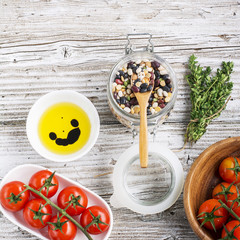 Assorted legumes grains on a light background with ripe tomatoes, olive oil, herbs, pepper ingredients for lunch or dinner. Top view. The concept of  healthy home-cooked meal.
