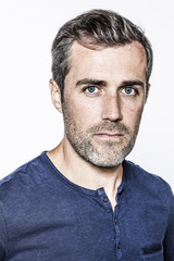 Fototapeta premium portrait of a handsome young bearded man with blue eyes and freckles looking smart over white background studio