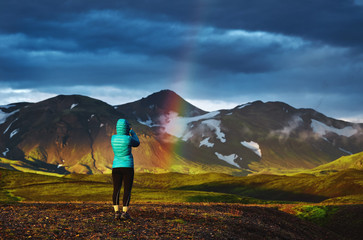 Travel to Iceland. Beautiful sunset in camping near Alftavatn lake. Icelandic landscape with mountains, sky and clouds. Trekking in national park Landmannalaugar. Rainy Evening with big rainbow.