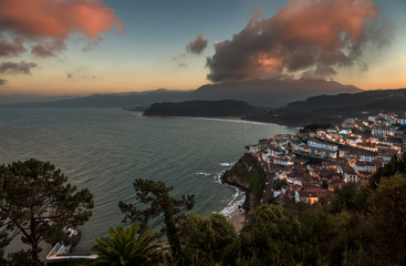 Beautiful view of coastal Asturias sea village Lastres in Spain, Europe during sunset or dusk. Gorgeous panorama of nature traditional famous touristic summer beach destination at dawn.