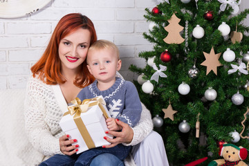 Obraz na płótnie Canvas young mother and little son in front of Christmas tree
