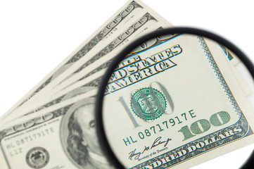 100 US Dollar banknotes under magnifying glass