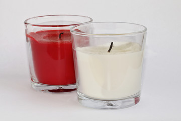 Dos velas, blanca y roja, apagadas sobre fondo blanco