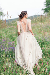 Bride in a beautiful dress with a bouquet of flowers and greener