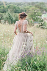 Bride in a beautiful dress with a bouquet of flowers and greener