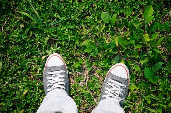 Top view of shoes and blue jean on nature green ground grass, selfie.