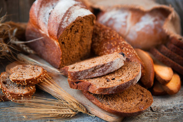 Assortment of fresh baked bread on wooden table background