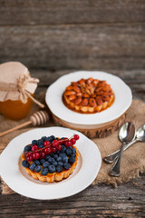 Almonds tart and Walnut tartlets with custard and berries on woo