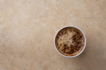 plastic cup of coffee and foam from above