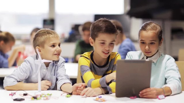kids with tablet pc programming at robotics school