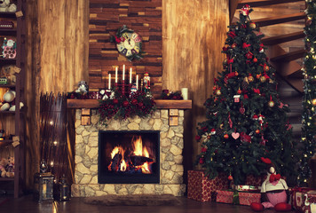 Beautiful holiday decorated room with Christmas tree, fireplace at night. Led lighting, cozy home scene. Nobody there.