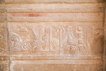 stone wall with Egyptian carving figures and hieroglyphs, with woman giving birth baby, other mother breastfeeding baby, in Kom Ombo Temple, Aswan, Egypt, Africa
