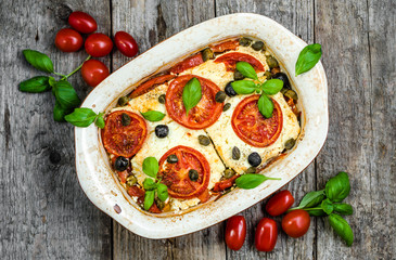Feta baked with tomatoes. Greek food of mediterranean diet. Vegetarian dish for healthy eating.