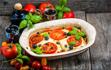 Feta baked with tomatoes. Greek food of mediterranean diet. Vegetarian dish for healthy eating.