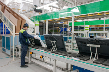 closeup line conveyor assembly and packing televisions in a workshop