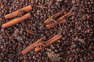 seasoning cinnamon (Cinnamomum) and anise (Anisium vulgare Gaerto) lies on the coffee beans among Christmas pine cones, background, close-up