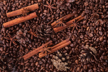 seasoning cinnamon (Cinnamomum) and anise (Anisium vulgare Gaerto) lies on the coffee beans among Christmas pine cones, background, close-up