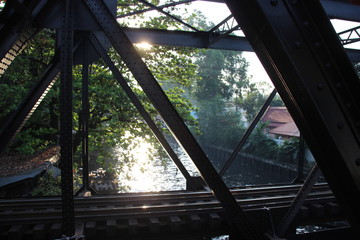 metal brige near river and reflecting sunlight