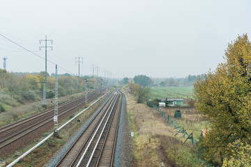 Fototapeta na wymiar Railway tracks receding through autumn farmland