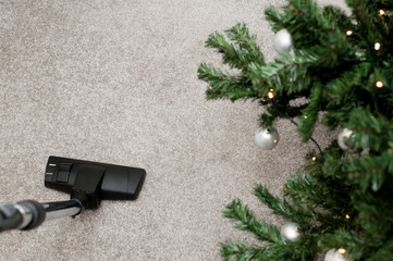 Close up of vacuum cleaner nozzle cleaning carpet at home, before and after holidays concept