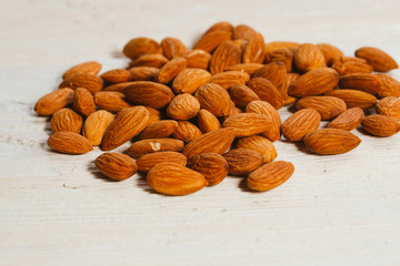 handful of almonds on a white wooden background