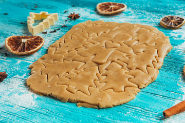 Gingerbread dough with molds for baking cinnamon on blue wooden table