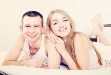 Young loving couple lounging in bed.