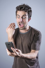 Stressed angry man is shouting at his cell phone, irritated with the service