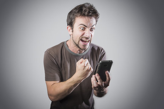 Stressed angry man is shouting at his cell phone, irritated with the service