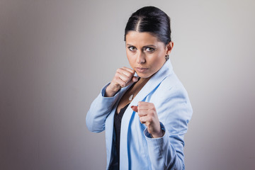 Young businesswoman making a defensive fight pose, crunching her fists.